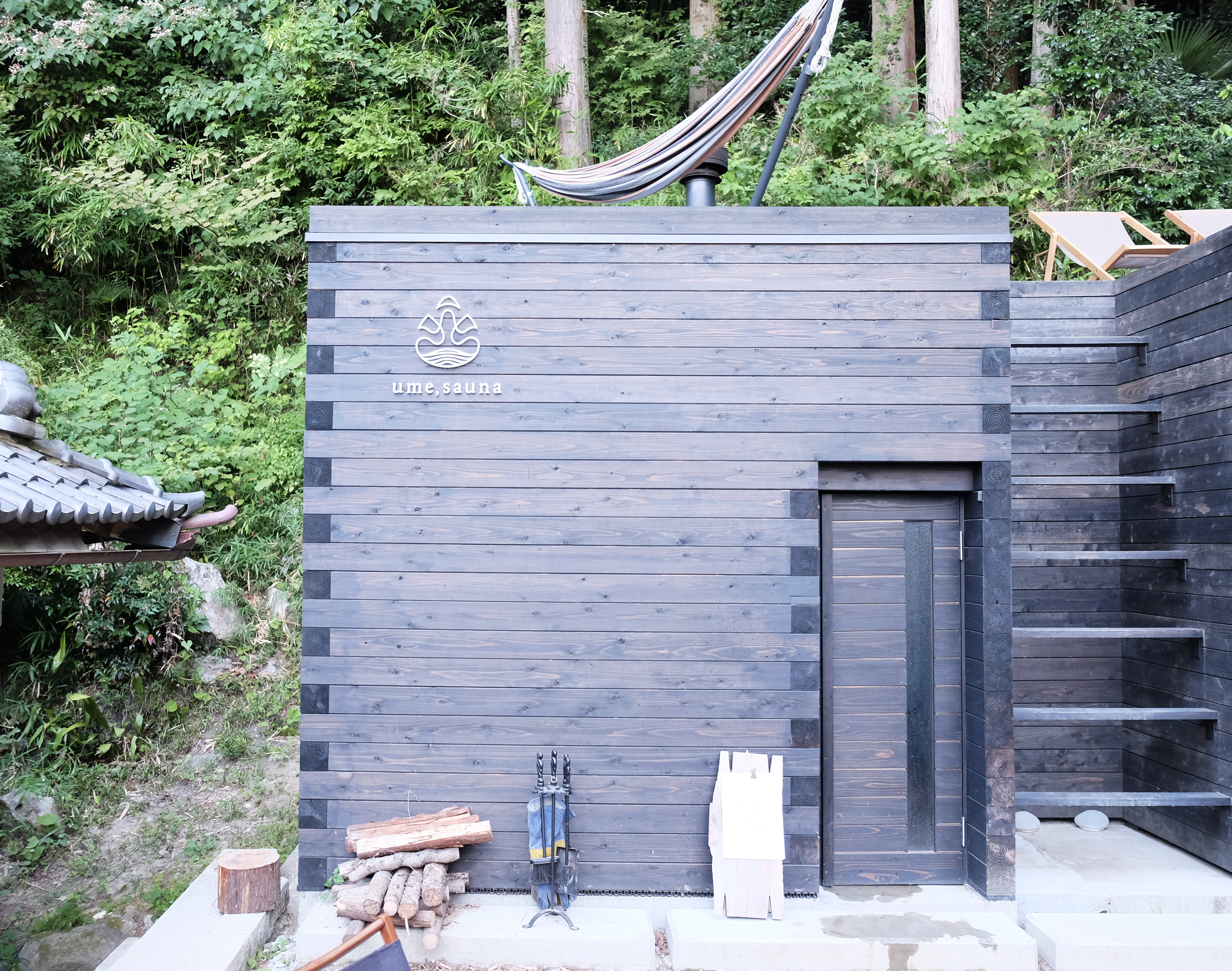 ume, saunaの建物外観と木壁に設置したサイン