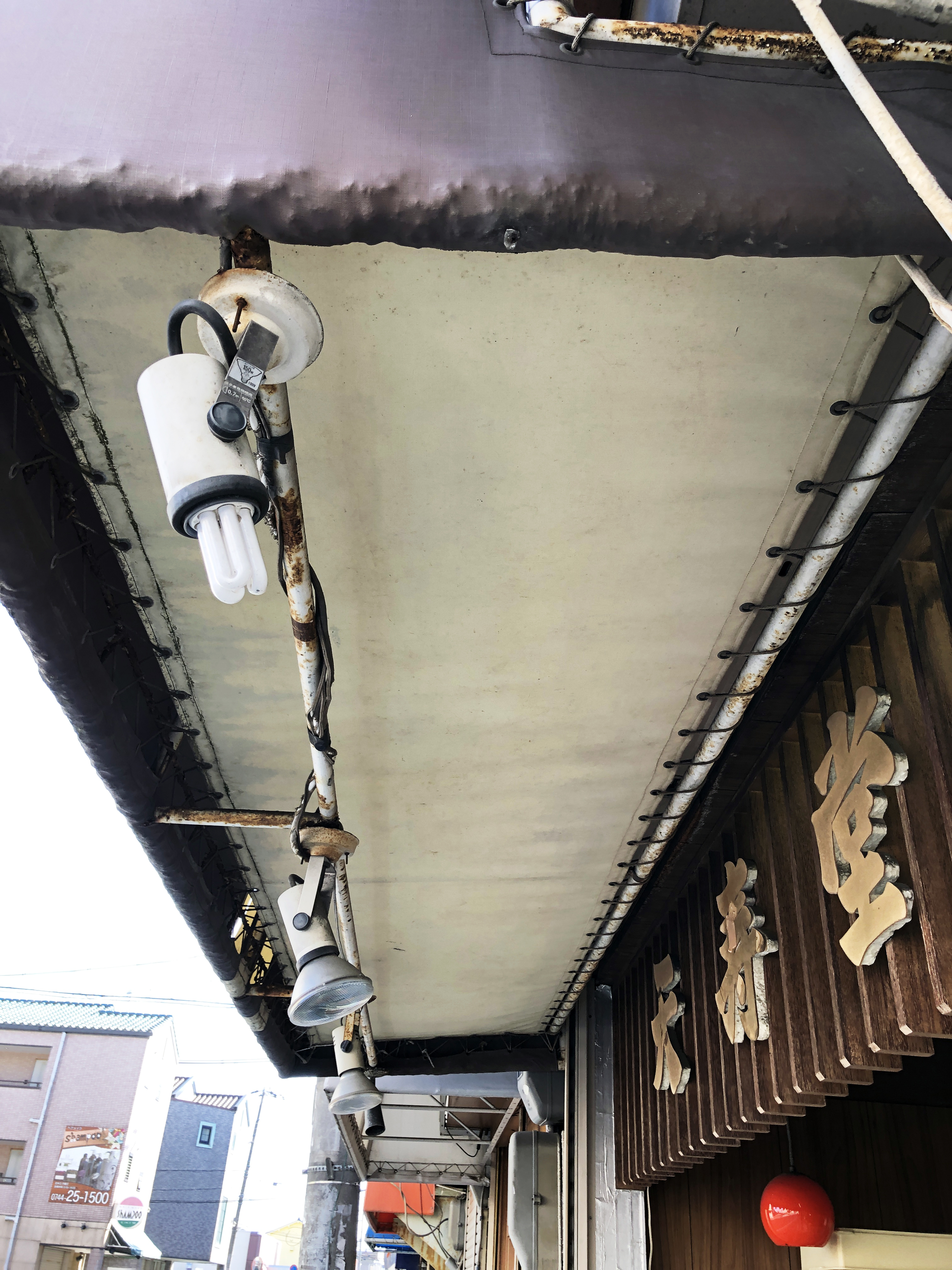 施工前の天寿堂のテント看板の裏側と照明
