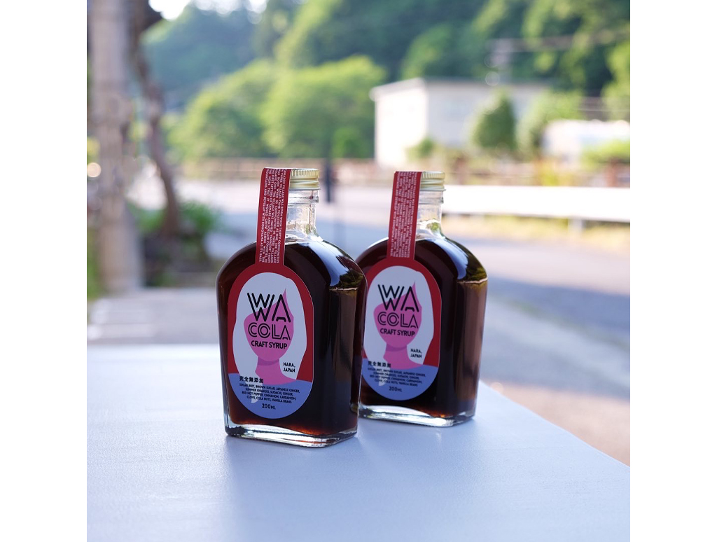 斜めから見たWa Colaのボトル2本とラベル