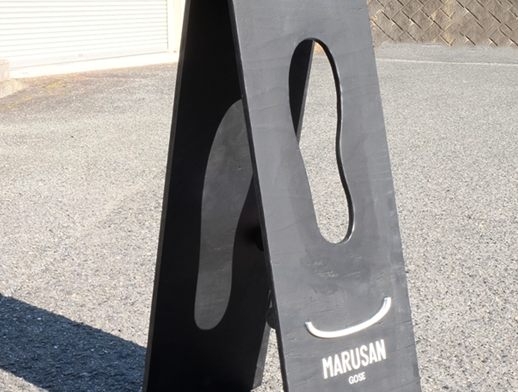 MARUSAN GOSEの看板の足型の切り抜きと差し込む光