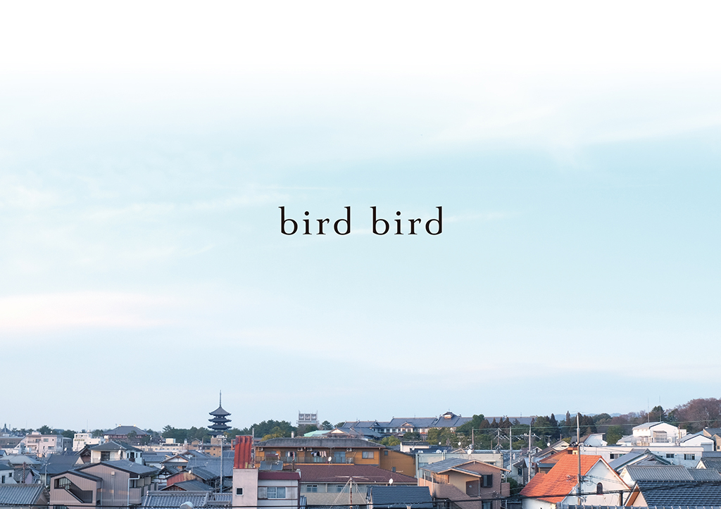 奈良の街並みを背景にしたbird birdのロゴタイプ