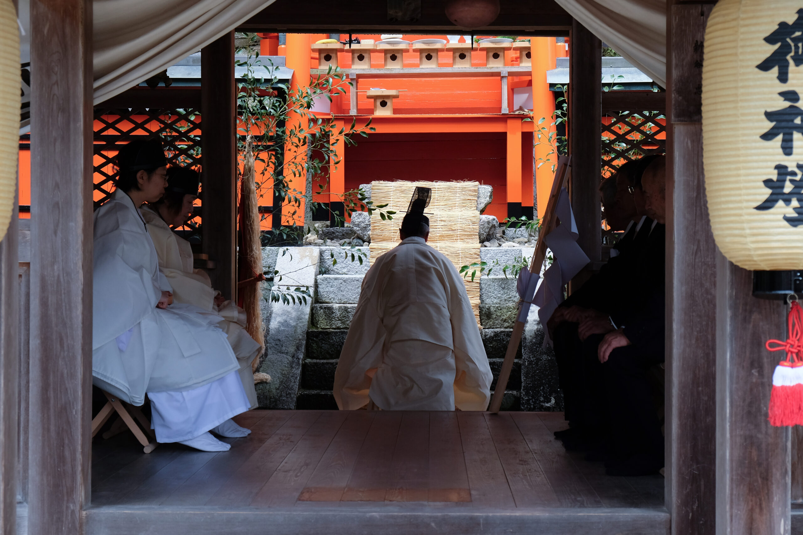 拝殿の入口から見た神事と朱色の本殿