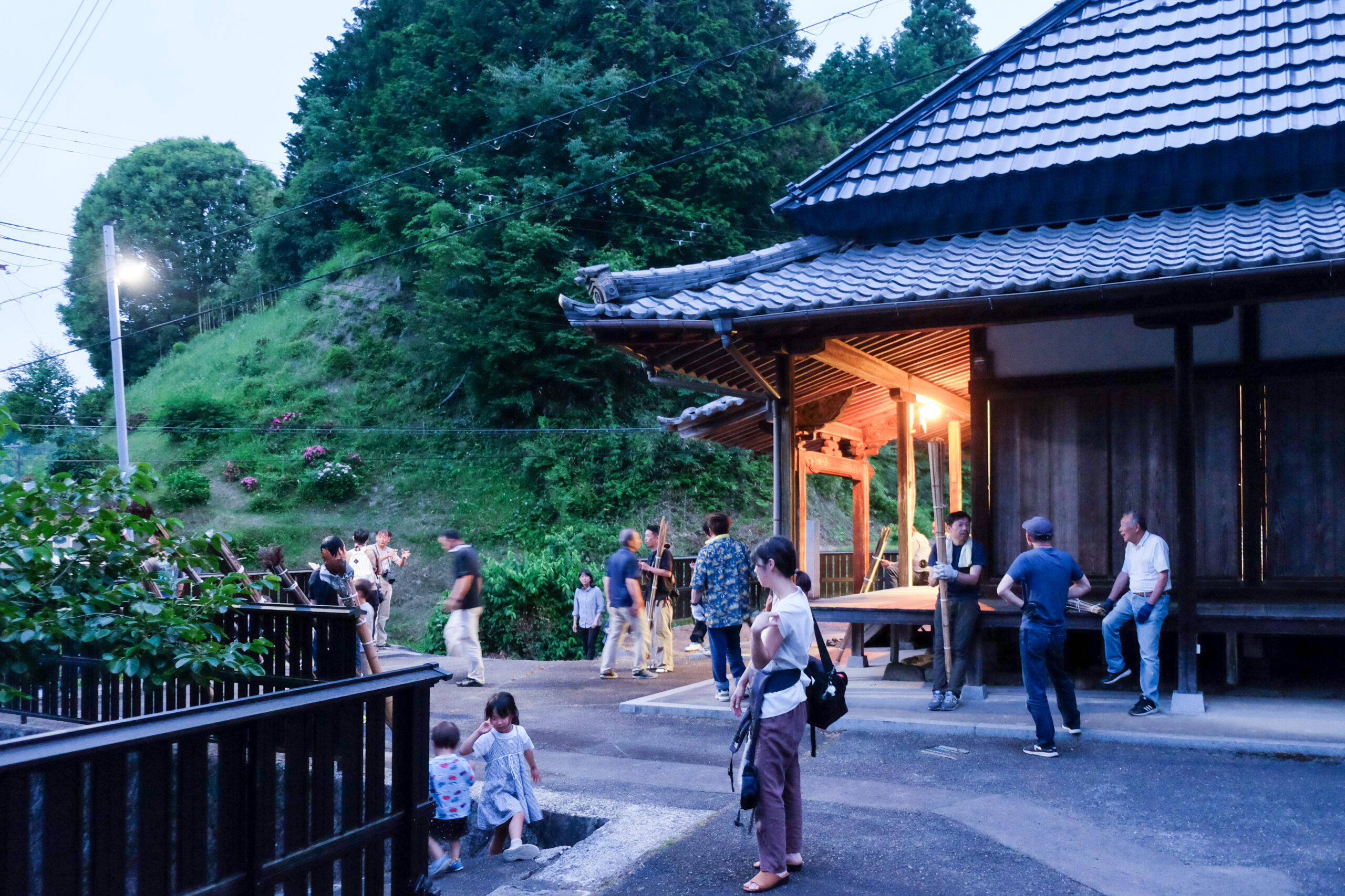 夕暮れのお堂の前に集まる地域の人々